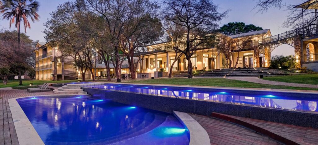 Elegant riverside view of Palm River Lodge on the Zambezi River — ideal for those wondering where to stay in Victoria Falls.